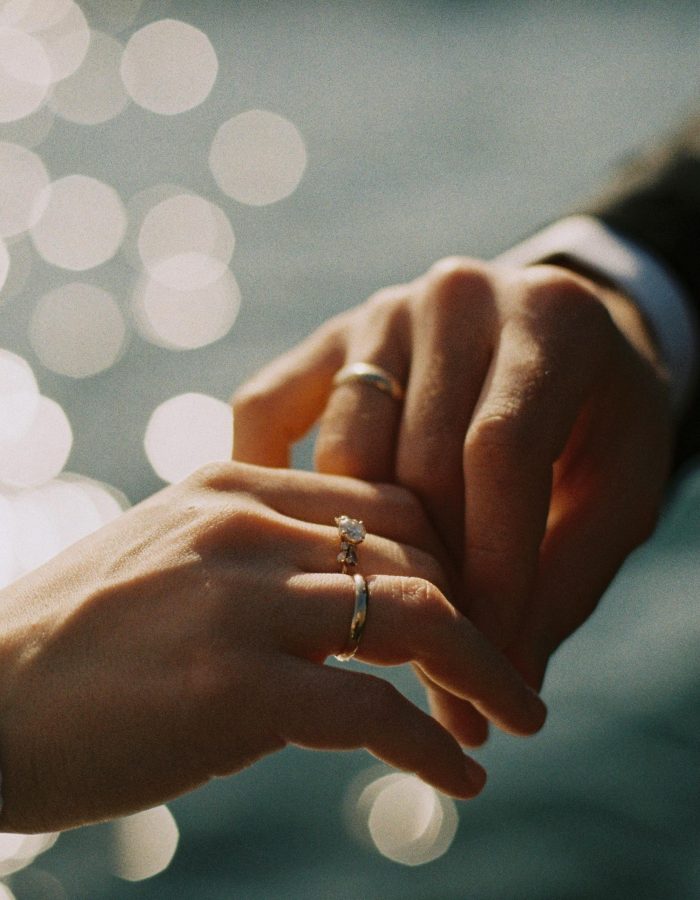 Intimate close-up of couple exchanging wedding rings, symbolizing love and commitment.